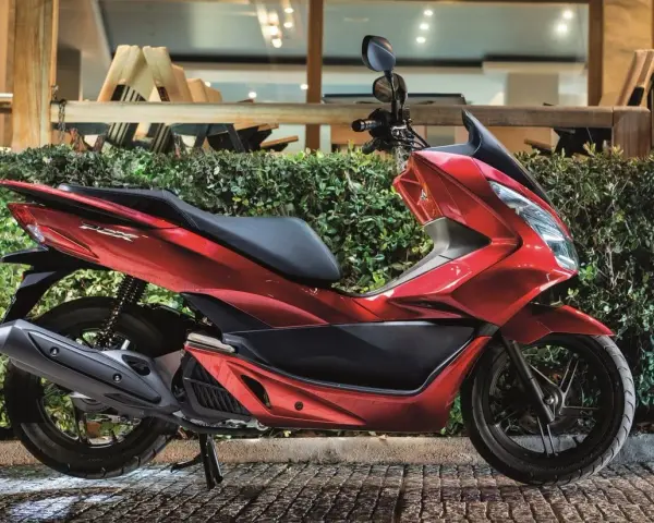 Lśniący czerwony skuter 125, idealny na 15 km dojazdy do pracy. Elegancki design i komfortowa jazda.