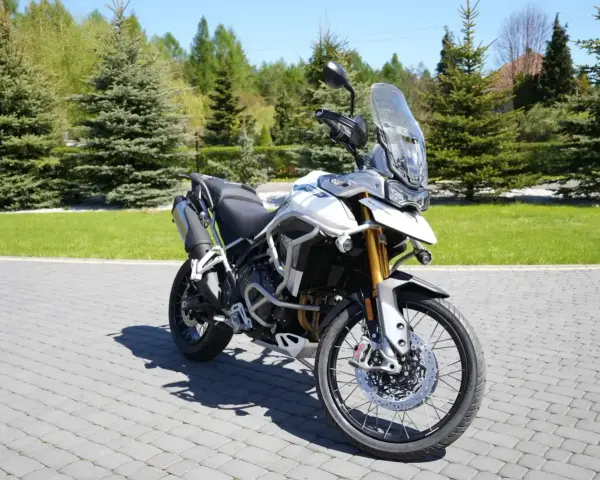 Biały motocykl Triumph Tiger 900 na brukowanej nawierzchni. Poznaj jego imponujące triumph tiger 900 dane techniczne.