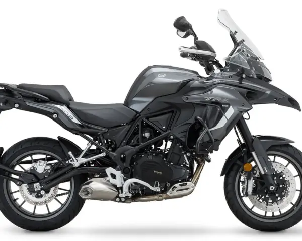 Szary motocykl Benelli TRK 502 z czarnym siedzeniem i bagażnikiem, gotowy na przygodę.