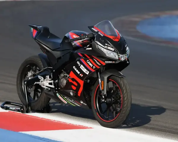 Czarna Aprilia RS 125 2T V-Max na torze wyścigowym, gotowa do osiągnięcia maksymalnej prędkości.