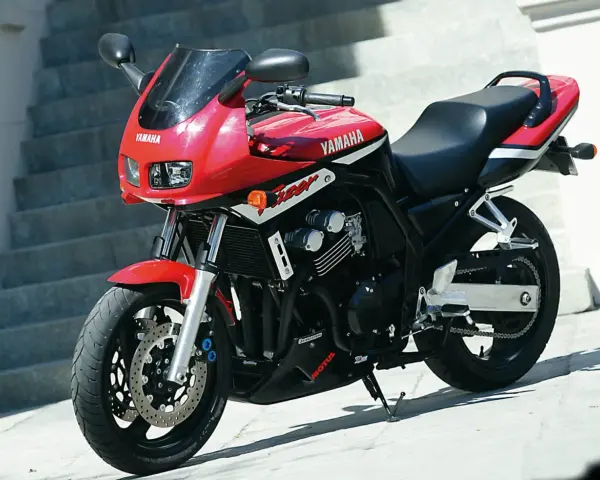 Czerwony motocykl Yamaha Fazer z czarnym siedzeniem i detalami, gotowy do jazdy.