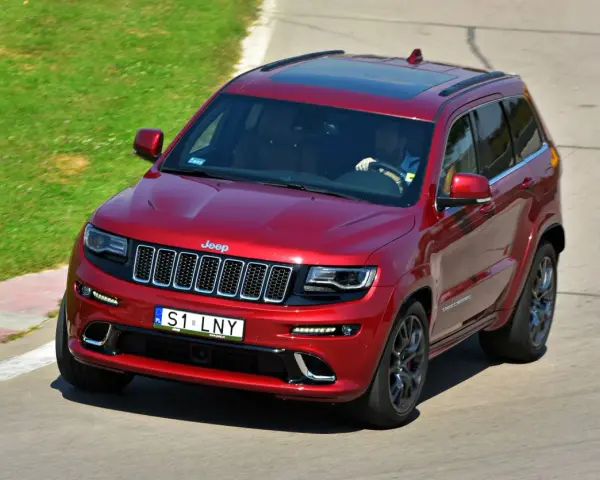 Czerwony Jeep Grand Cherokee na torze. Zastanawiasz się, ile kosztuje personalizowana rejestracja, gdy widzisz tablicę S1 LNY?