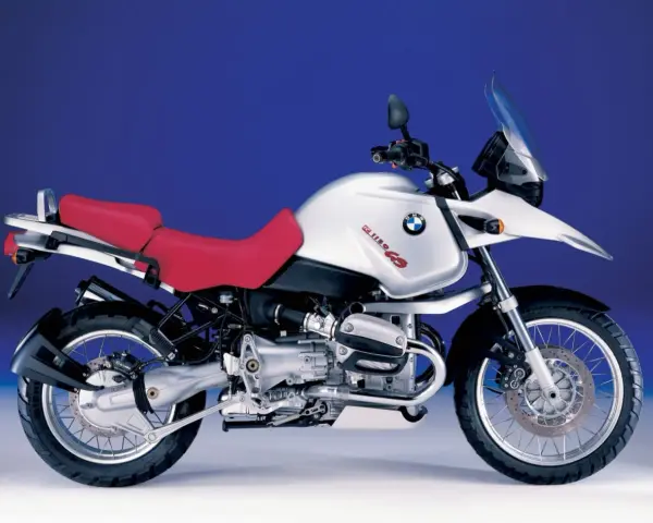 Srebrny motocykl BMW R 1150 GS z czerwoną kanapą, gotowy na przygodę.