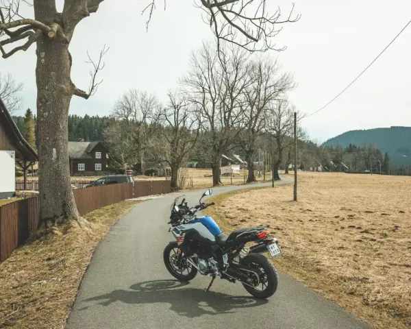 Motocykl czeka na przygodę na malowniczej drodze. Idealne miejsce na odkrywanie tras motocyklowych w Czechach.