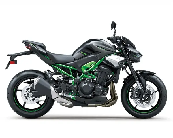 Czarny motocykl Kawasaki Z900 z zielonym stelażem i akcentami. Potężna maszyna gotowa na przygodę.