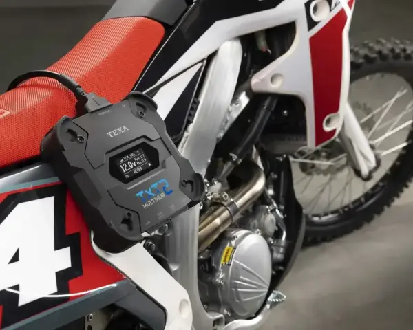 Urządzenie diagnostyczne TEXA TXT2 podłączone do motocykla, sprawdzające, czy jest **brak iskry**.