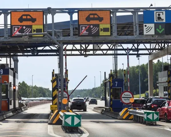Pobieranie opłat na autostradzie A4. Samochody zbliżają się do bramek, na których wyświetlane są informacje o opłatach.