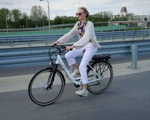 Młoda kobieta na rowerze elektrycznym, zastanawia się, czy na rower elektryczny trzeba mieć prawo jazdy.