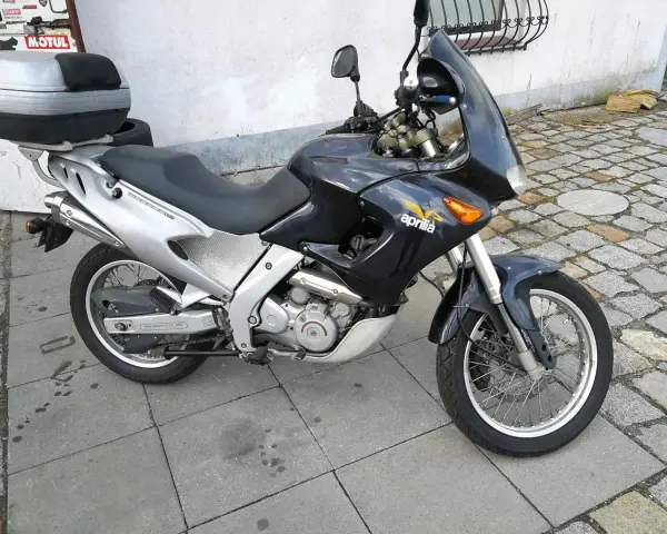 Czarny motocykl Aprilia Pegaso 650 z kufrem na bagaż, gotowy na przygodę.