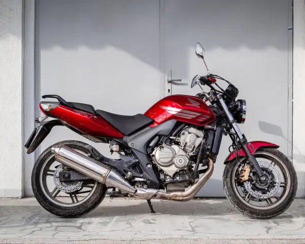 Czerwony motorower Honda Hornet, idealny do miasta. Zastanawiasz się, ile kosztuje motorower tej klasy?
