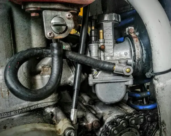Gaźnik motocyklowy z widoczną dyszą wolnych obrotów.