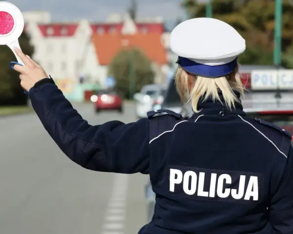 Policjantka z tarczą zatrzymuje ruch. Kierowca, który już raz dostał mandat, musi uważać, by nie popełnić kolejnego wykroczenia.