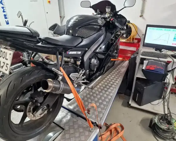 Czarny motocykl na hamowni, przygotowany do testów. Pomiar mocy i momentu obrotowego, czyli blokowanie motocykla na A2, to klucz do optymalizacji osiągów.