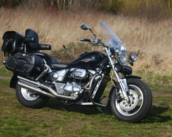 Czarny Suzuki Marauder z sakwami i szybą, gotowy na podróż przez jesienne krajobrazy.