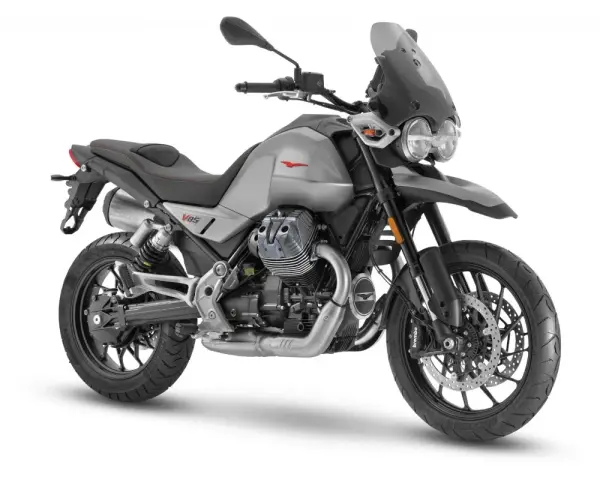 Srebrny motocykl Moto Guzzi V85 TT z charakterystycznym silnikiem V-twin, gotowy na przygodę.