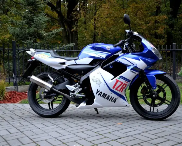 Sportowy motocykl Yamaha TZR 50 w niebiesko-białych barwach, gotowy do jazdy. Sprawdź jego atrakcyjną yamaha tzr 50 cena!