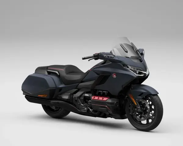 Ciemnoszary motocykl Honda Gold Wing z czarnym siedzeniem i kuframi, gotowy na dalekie podróże.