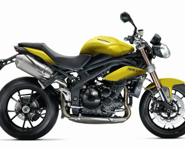Żółty motocykl Triumph Speed Triple 1050 z czarnymi felgami i wydechem.