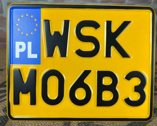 Żółta tablica rejestracyjna z oznaczeniem PL i numerem WSK M06B3.
