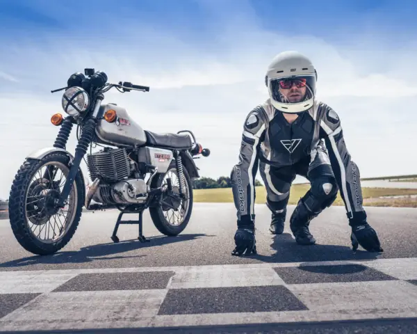 Motocykl MZ ETZ 250 i zawodnik w kombinezonie i kasku na starcie wyścigu. Gotowi do startu!