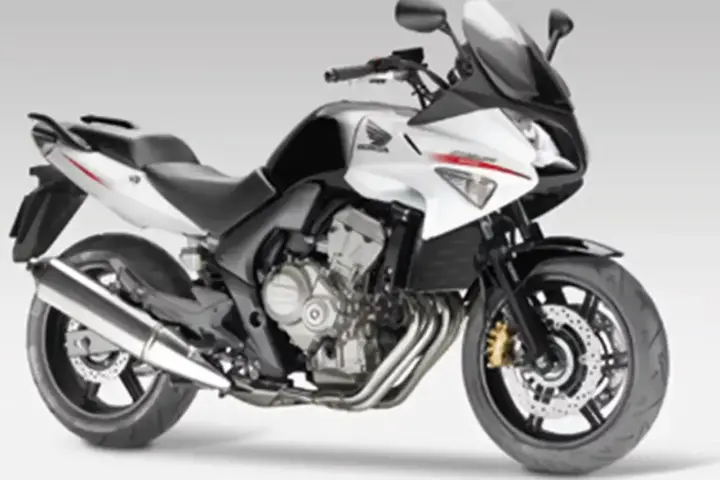Sportowy motocykl Honda CBF 600 w kolorze biało-czarnym. Jego waga jest optymalna do zwinnego manewrowania.