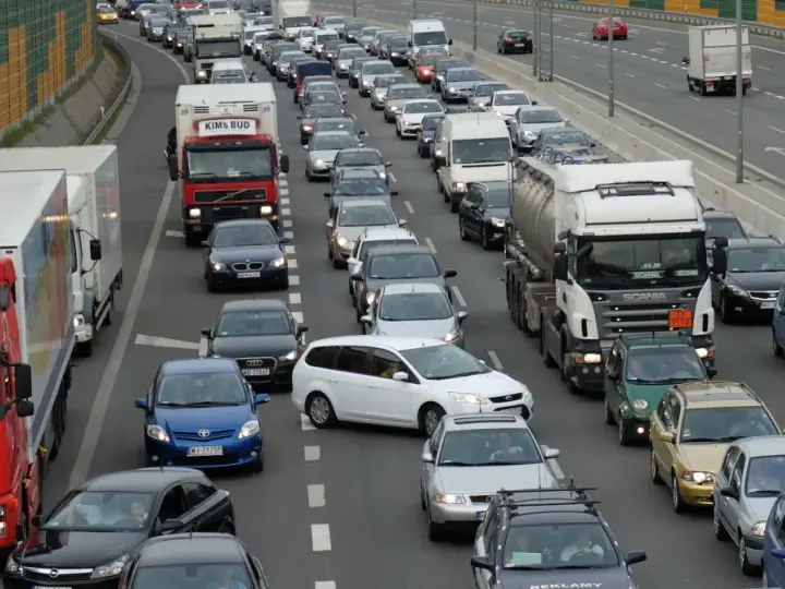 Korki na autostradzie, wiele samochodów i ciężarówek stoi w miejscu. Aktualne utrudnienia na drogach uniemożliwiają płynny ruch.