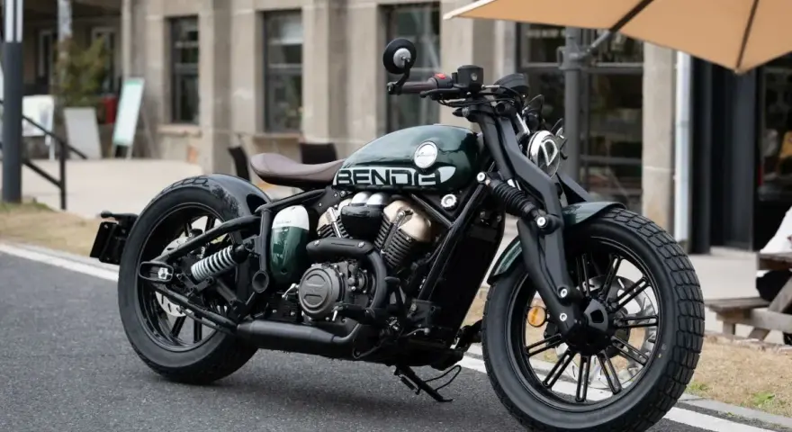 Stylowy, zielony motocykl typu cruiser z brązowym siedzeniem. Idealny do miejskich podróży, mógłby znaleźć się w rankingu motocykli cruiser.