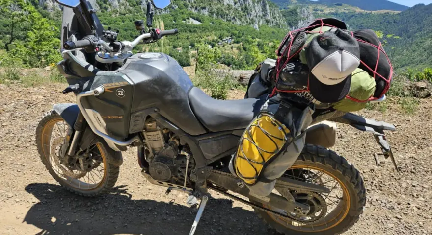 Motocykl Kove 800X Rally gotowy na przygodę, z bagażem na wyprawę po górskich drogach.