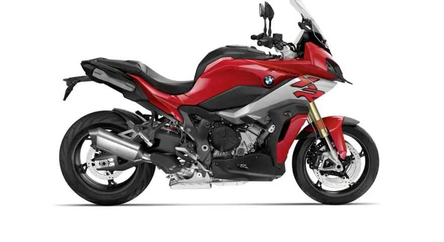 Czerwony motocykl sportowo-turystyczny BMW XR z szarymi akcentami i czarnym siedzeniem, gotowy na przygodę.