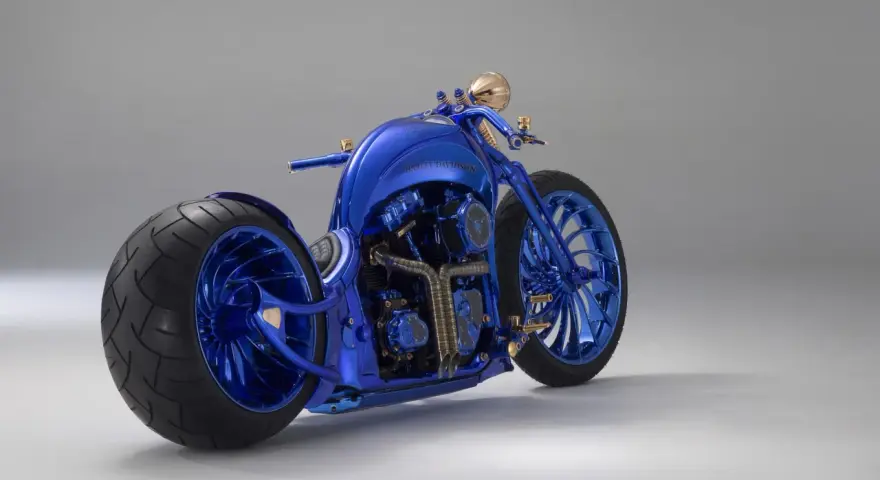 Błyszczący, niebieski Harley-Davidson, prawdopodobnie najdroższy motor na świecie, z masywnymi kołami i złotymi detalami.
