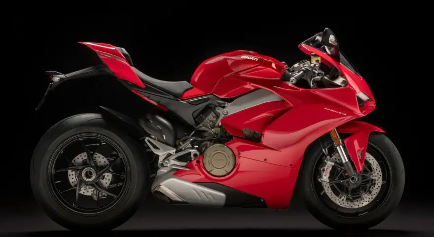 Czerwony motocykl Ducati Panigale V4 na czarnym tle. Poznaj jego imponującą moc i sprawdź, jaka jest jego ducati panigale v4 cena.