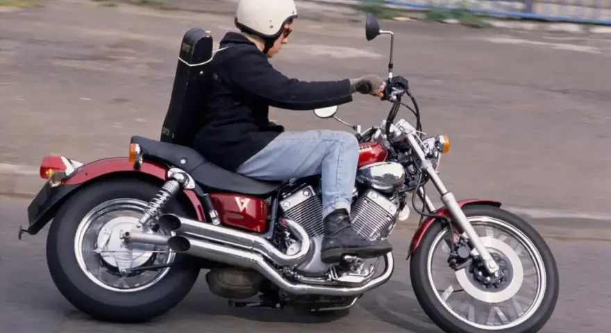 Motocyklista na czerwonym Yamaha Virago 535, z futerałem na instrumenty z tyłu. Dane techniczne tego modelu są imponujące.
