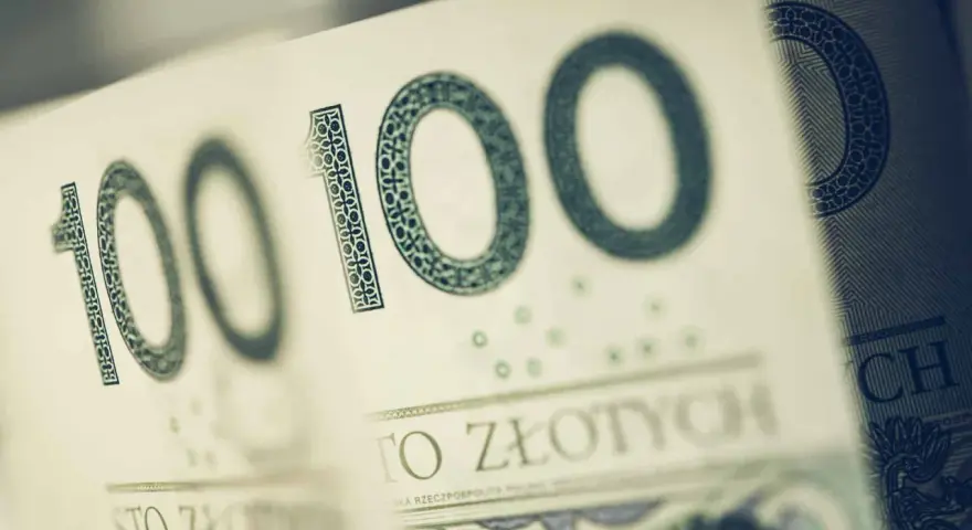 Sto złotych na zakup motocykla. Widoczne fragmenty banknotów 100 zł.