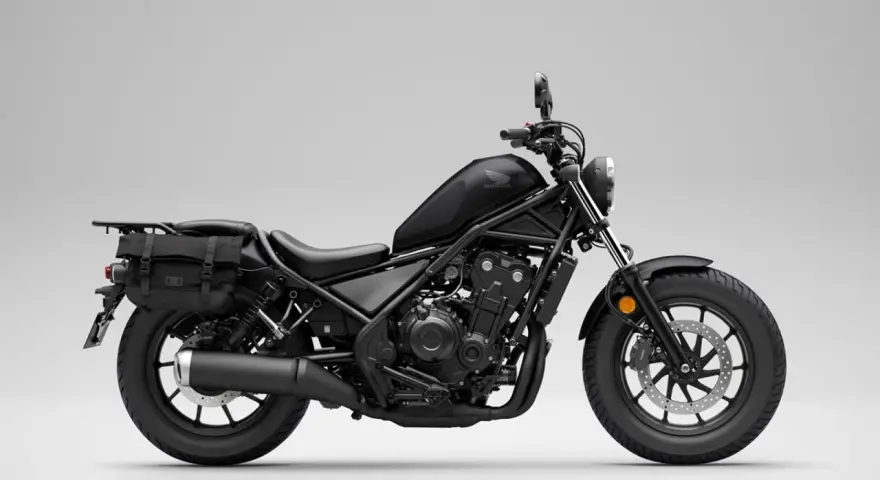 Czarny motocykl Honda Rebel 500 z sakwami, gotowy na podróż. Jego prędkość maksymalna pozwala na swobodne pokonywanie tras.