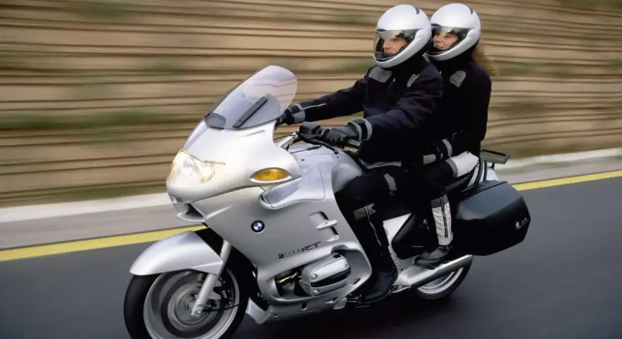Para podróżuje na srebrnym BMW R 1100 RT. Choć motocykl ten ma swoje wady, podróż wygląda na komfortową.