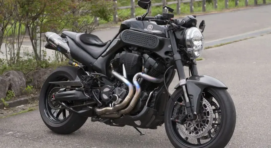 Czarny Yamaha MT-01 z customowym wydechem i sportowymi dodatkami, gotowy na jazdę po krętych drogach.
