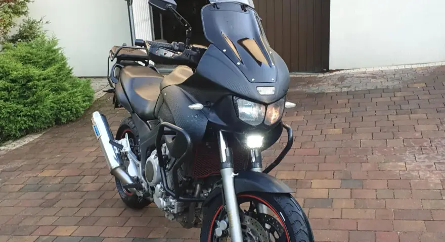 Czarny motocykl Yamaha TDM 850 z turystyczną owiewką i dodatkowymi światłami LED, gotowy na przygodę.