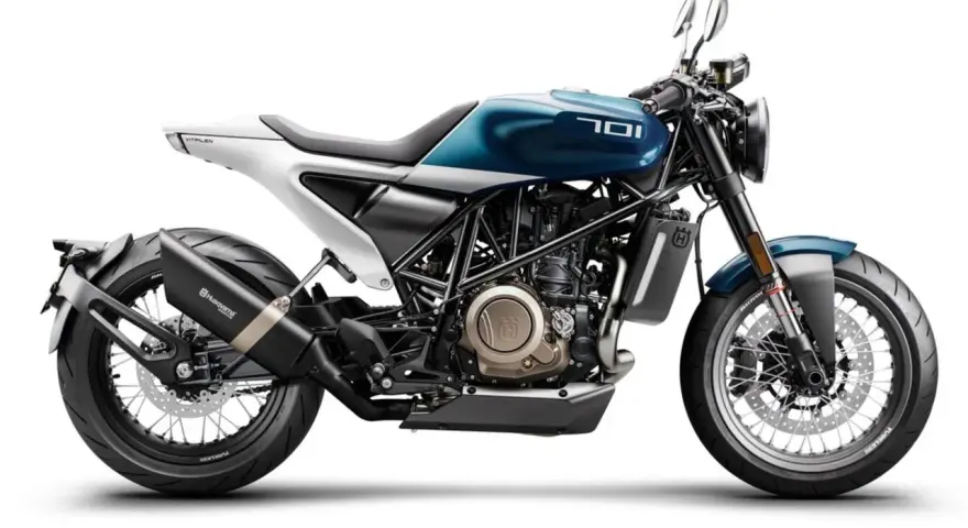 Stylowy motocykl Husqvarna Vitpilen 701 w kolorze niebiesko-białym, z widocznym silnikiem i wydechem.