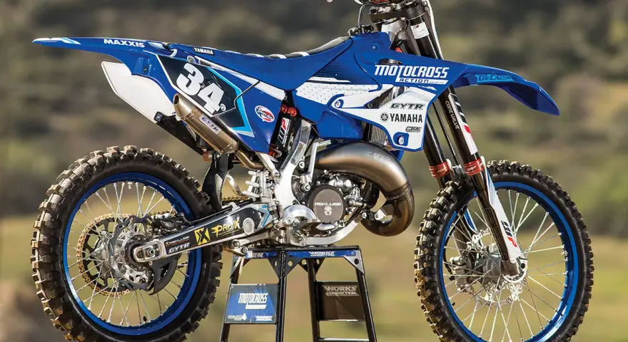 Niebiesko-biały motocykl Yamaha YZ 125 na stojaku. Ile koni ma Yamaha YZ 125? Ten model to potężna maszyna terenowa.