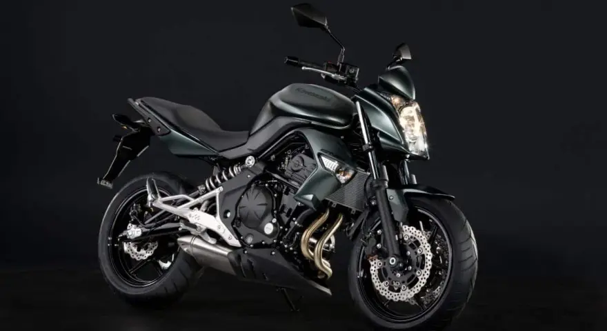 Zielony motocykl Kawasaki ER6N z ciemnym tłem.