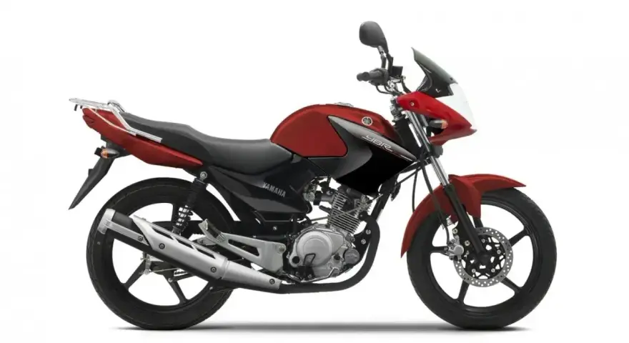 Czerwony motocykl Yamaha YBR 125, z czarnymi akcentami i bagażnikiem. Wady tego modelu to m.in. brak wskaźnika paliwa.