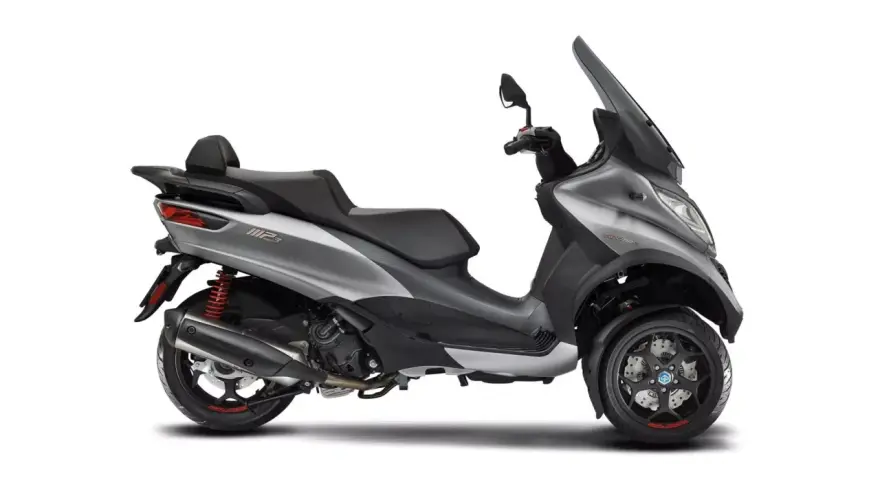 Srebrny Piaggio MP3 500, trójkołowy skuter z czarnym siedzeniem i dużą szybą. Poznaj jego piaggio mp3 500 dane techniczne.