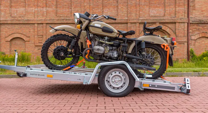 Jak przewieźć motocykl na zwykłej przyczepie? Oto przykład z użyciem pasów transportowych do zabezpieczenia ciężkiego motocykla.