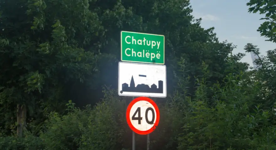 Znak d42: Chatupe Chalëpe, zarys zabudowań i ograniczenie prędkości do 40 km/h.