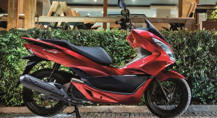 Lśniący czerwony skuter 125, idealny na 15 km dojazdy do pracy. Elegancki design i komfortowa jazda.
