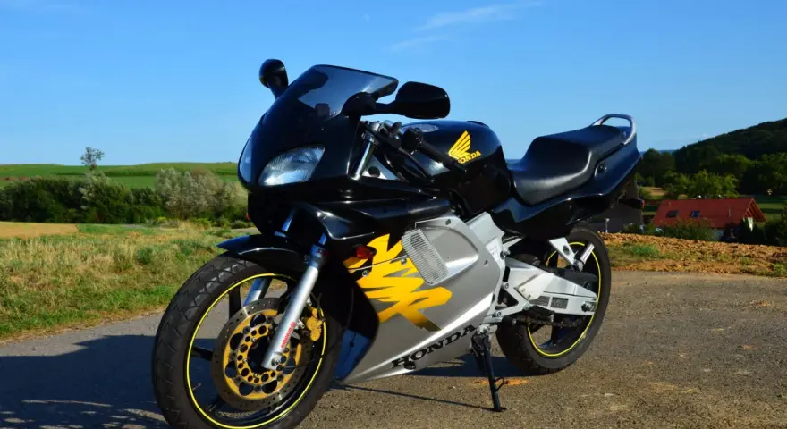 Czarny motocykl Honda NSR 125 z żółtymi akcentami, idealny do poznania jego honda nsr 125 dane techniczne.