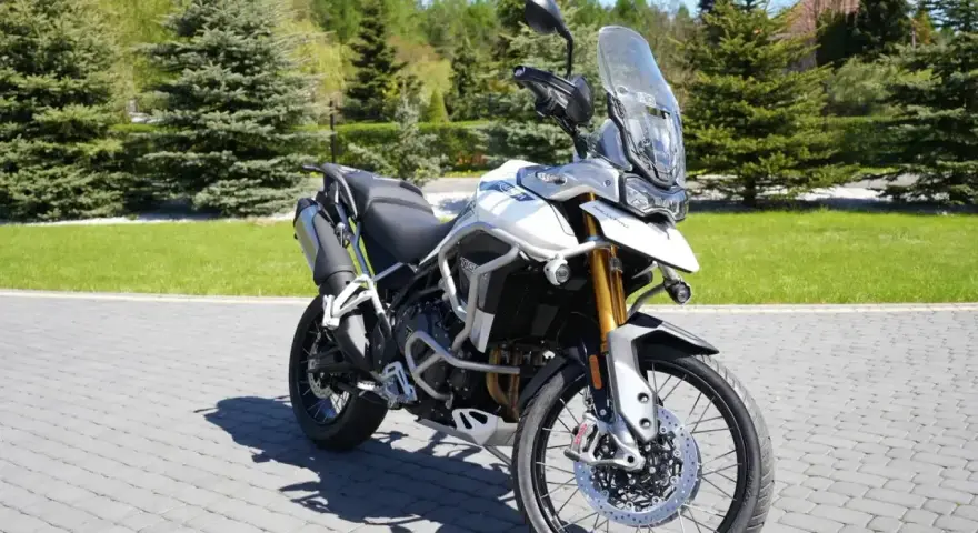 Biały motocykl Triumph Tiger 900 na brukowanej nawierzchni. Poznaj jego imponujące triumph tiger 900 dane techniczne.