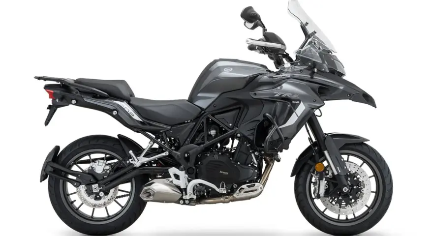Szary motocykl Benelli TRK 502 z czarnym siedzeniem i bagażnikiem, gotowy na przygodę.