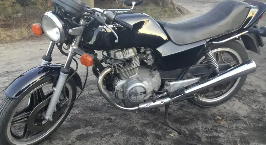 Czarny motocykl Honda CB250T z lat 80. stoi na ziemi.