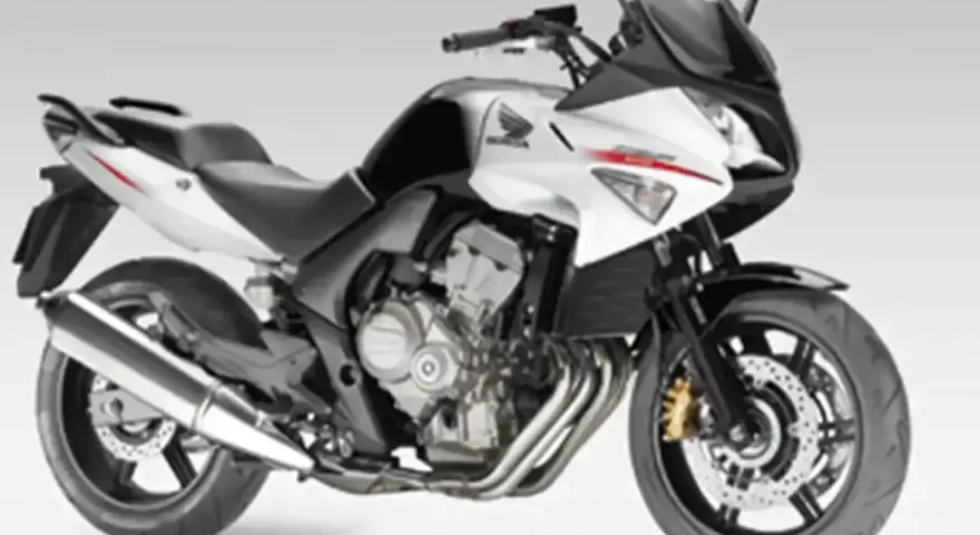 Sportowy motocykl Honda CBF 600 w kolorze biało-czarnym. Jego waga jest optymalna do zwinnego manewrowania.
